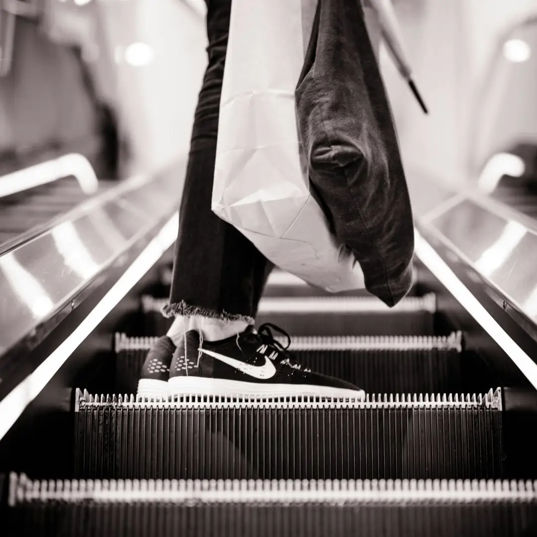 escalator with guy wearing nike trainers